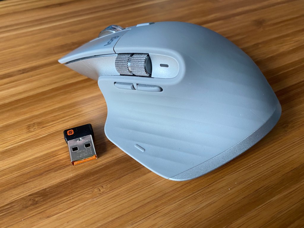 Logitech MX Master 3 mouse next to wireless dongle