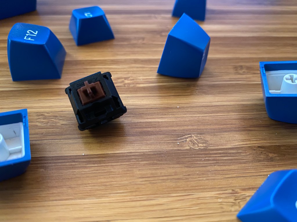 Cherry MX Brown switch surrounded by keycaps.