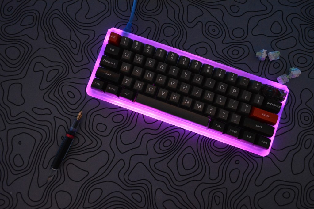 Custom mechanical keyboard on a mousepad with a fountain pen and mechanical switches.