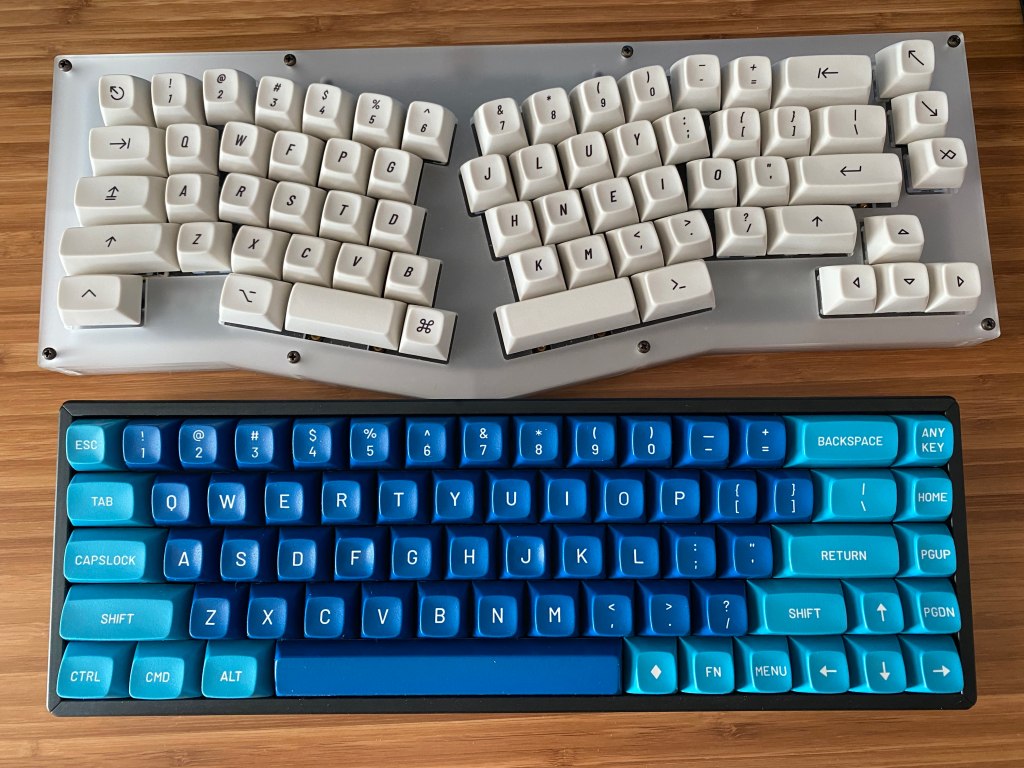 Mechanical keyboard with Colemak layout next to keyboard with QWERTY layout.
