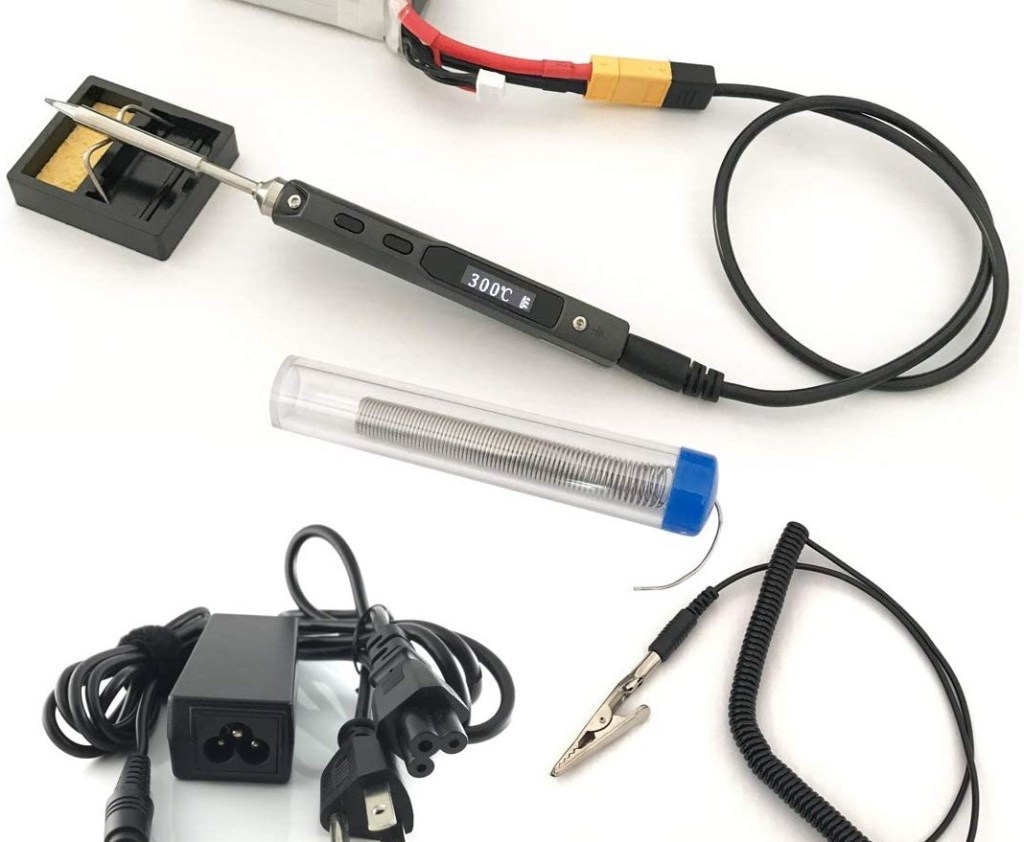 TS100 soldering iron next to wires and solder.