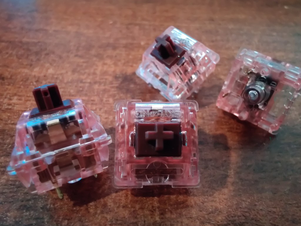 Close up of Epomaker Chocolate Brown keyboard switches on a desk.