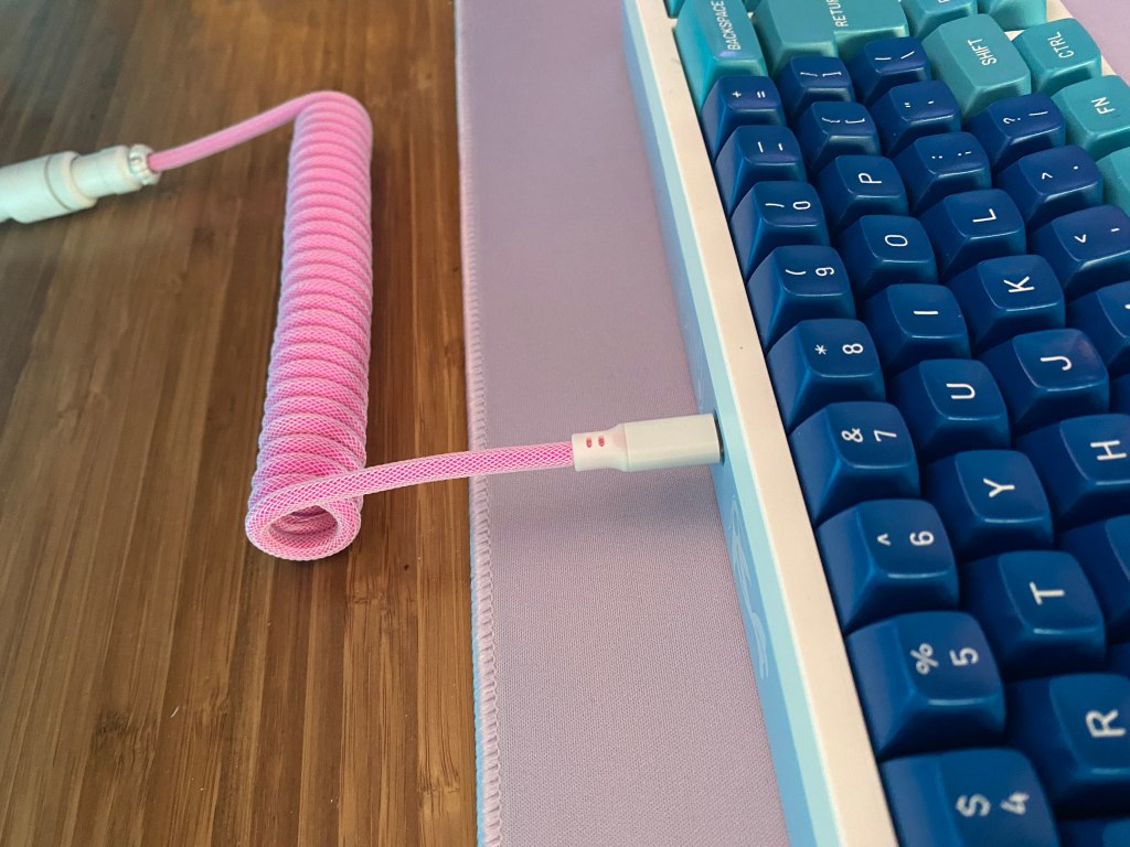 Custom pink cable plugged into a mechanical keyboard.