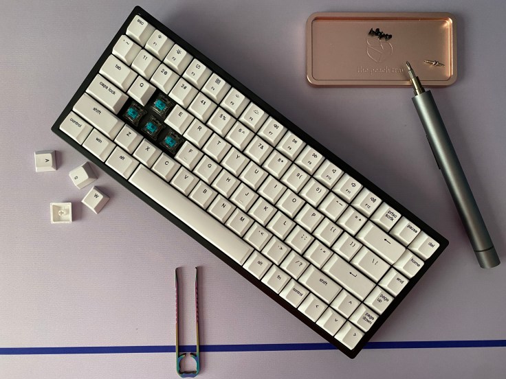 Vissles V84 mechanical keyboard on a desk with screws and tools